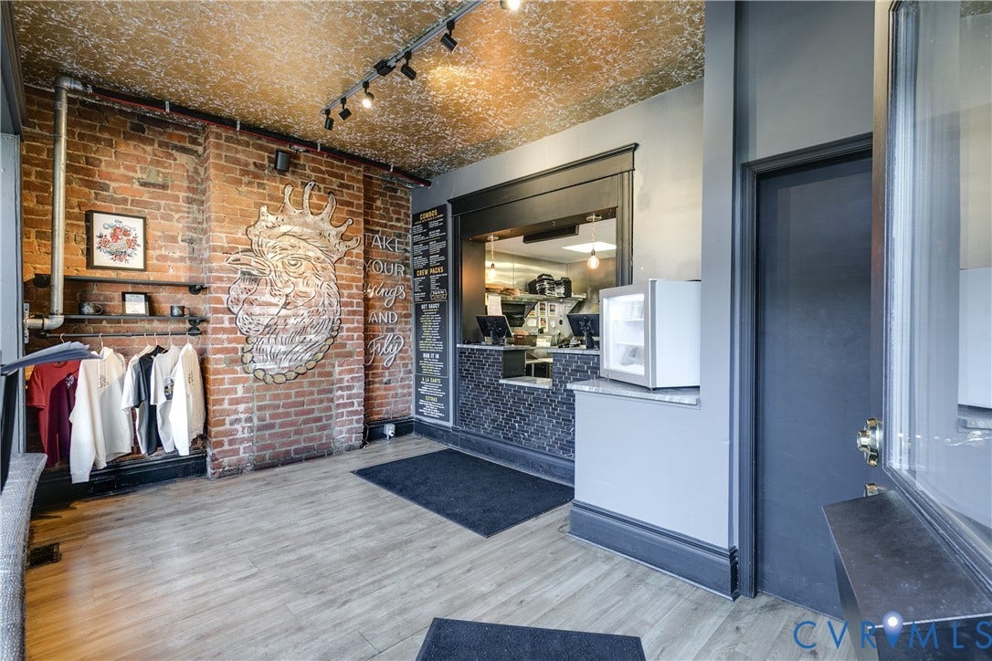 2523 W Main Street, The Fan, Richmond, VA 23220 Exposed brick wall, wood-finish flooring, track lighting, service counter with mosaic tile finish, and a windowed door