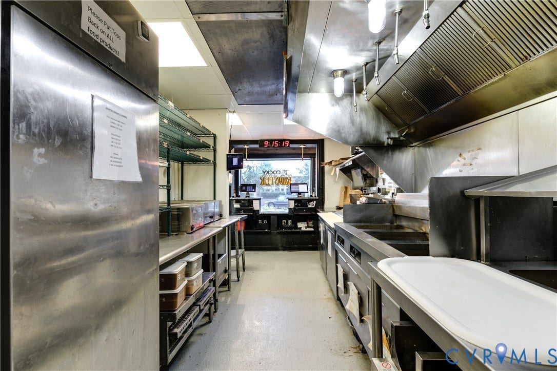 2523 W Main Street, The Fan, Richmond, VA 23220 Commercial kitchen featuring extensive stainless steel countertops, industrial-grade range hood, built-in stainless steel appliances, and overhead fluorescent lighting