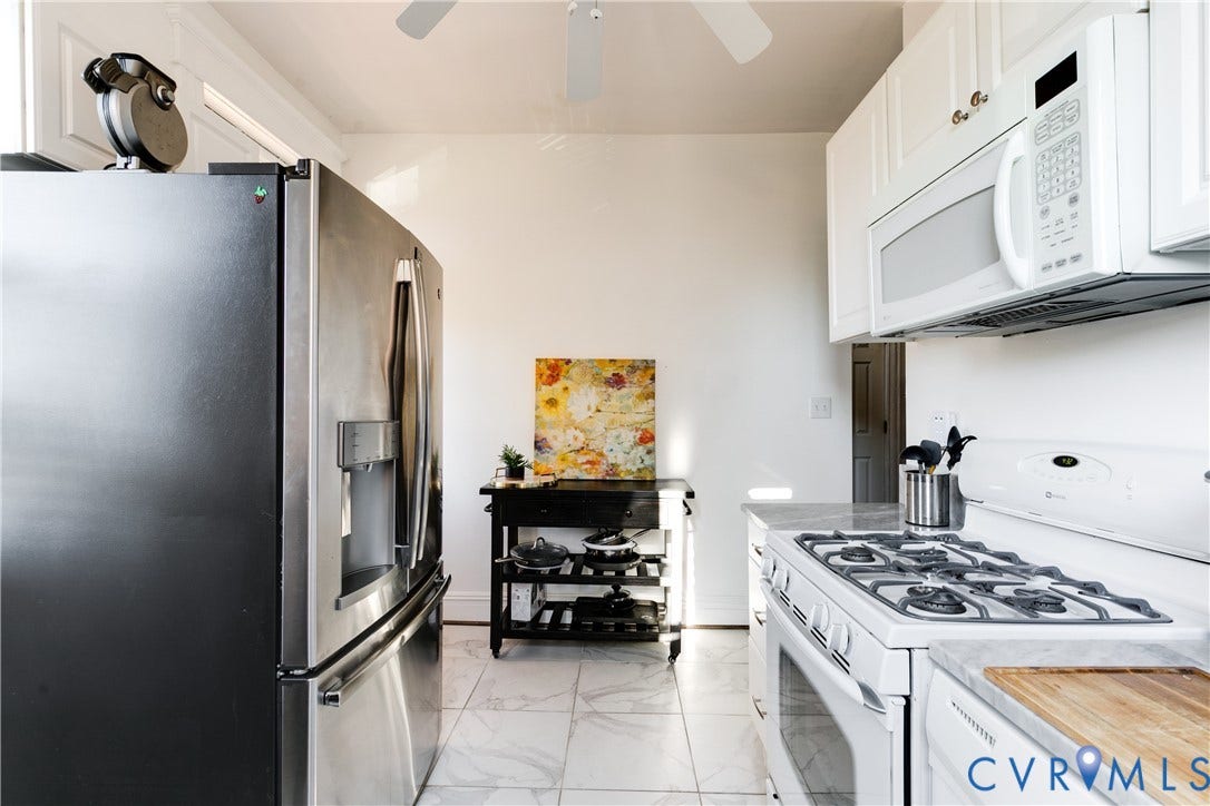 2523 W Main Street, The Fan, Richmond, VA 23220 Kitchen featuring white cabinetry, a built-in microwave, a gas range, stone-finish countertops, and a stainless steel refrigerator