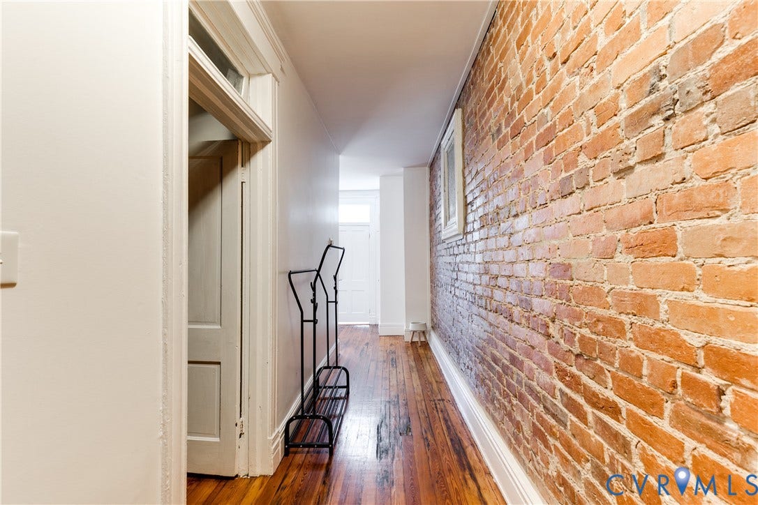 2523 W Main Street, The Fan, Richmond, VA 23220 Exposed brick wall, hardwood flooring, white baseboards, and a transom window