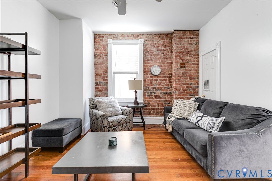 2523 W Main Street, The Fan, Richmond, VA 23220 Exposed brick accent wall, wood-finish flooring, white painted walls, and a ceiling fan
