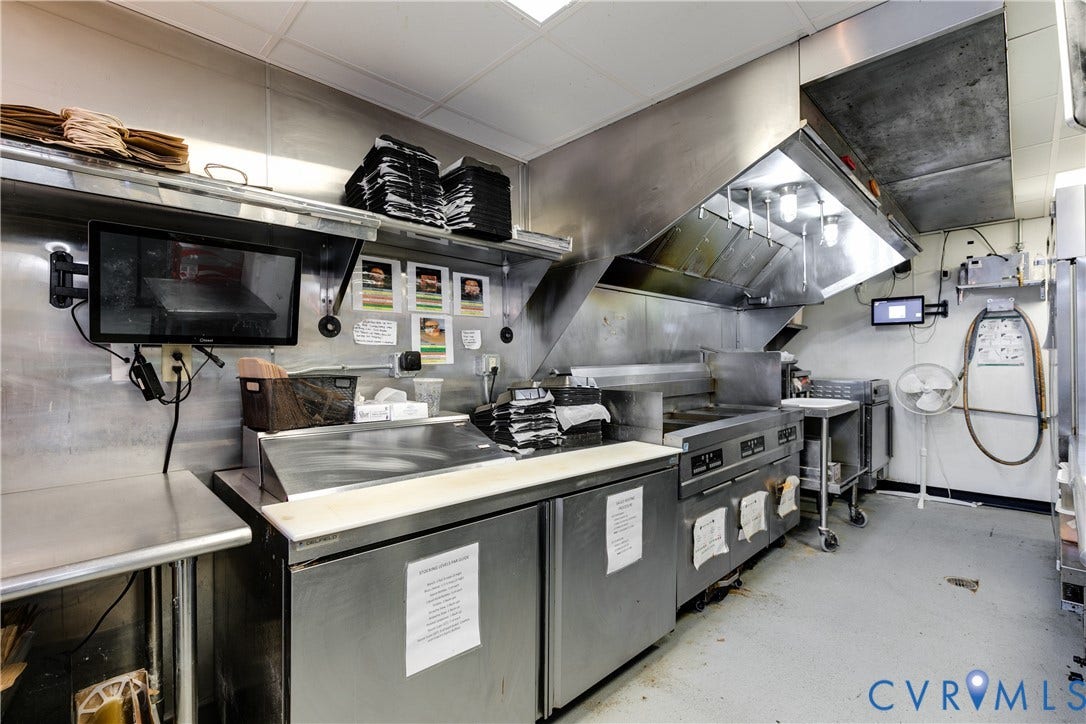 2523 W Main Street, The Fan, Richmond, VA 23220 Commercial kitchen featuring stainless steel countertops, built-in refrigeration, and a large exhaust hood