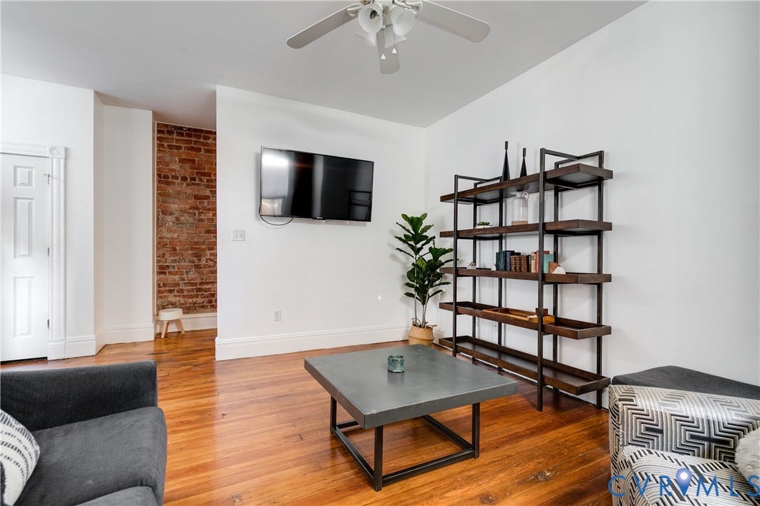 2523 W Main Street, The Fan, Richmond, VA 23220 Hardwood flooring, exposed brick accent wall, white painted walls, ceiling fan, and white trim