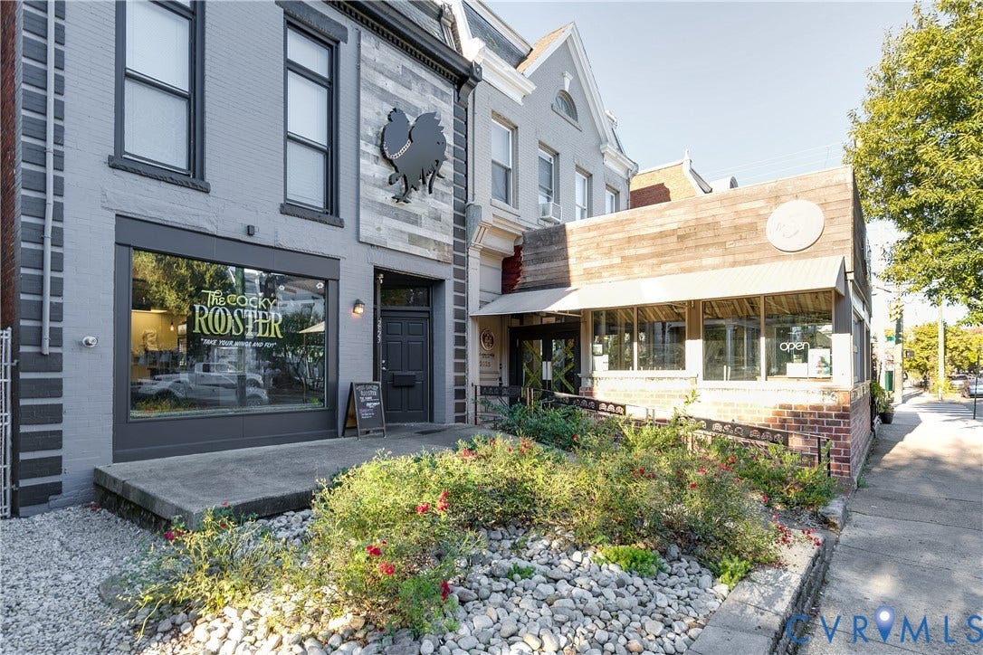 2523 W Main Street, The Fan, Richmond, VA 23220 Grey painted facade with black trim windows, a prominent display window, a solid black entry door, and an exterior wall featuring horizontally oriented wood-finish panels