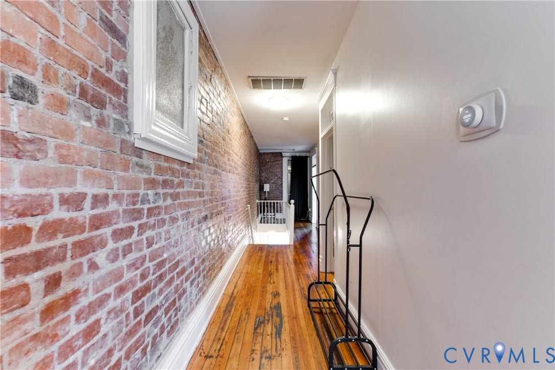 2523 W Main Street, The Fan, Richmond, VA 23220 Exposed brick wall, wood-finish flooring, white trim, recessed lighting, and wall-mounted thermostat