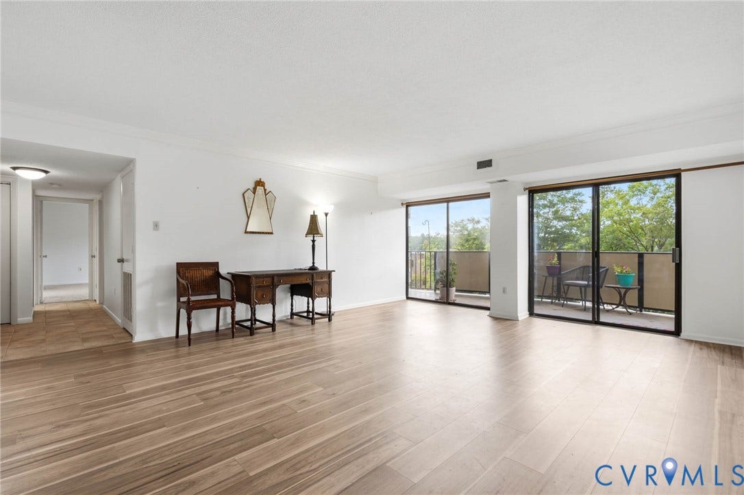 2956 Hathaway Road, #U407, Richmond, VA 23225 Spacious living area featuring wood-finish flooring, two large sliding glass doors, and recessed lighting in the hallway