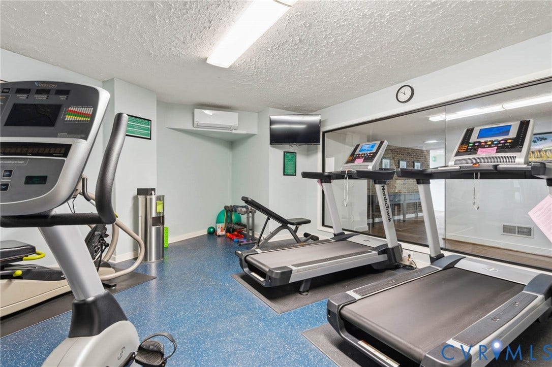 2956 Hathaway Road, #U407, Richmond, VA 23225 Recreational space featuring blue-patterned flooring, wall-mounted air conditioning unit, and built-in glass partition
