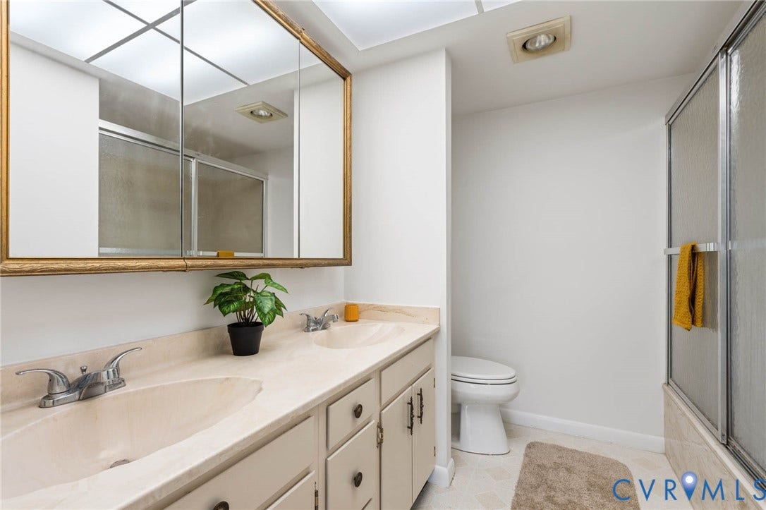 2956 Hathaway Road, #U407, Richmond, VA 23225 Dual vanity with integrated sinks, framed medicine cabinet, and a shower with sliding glass doors