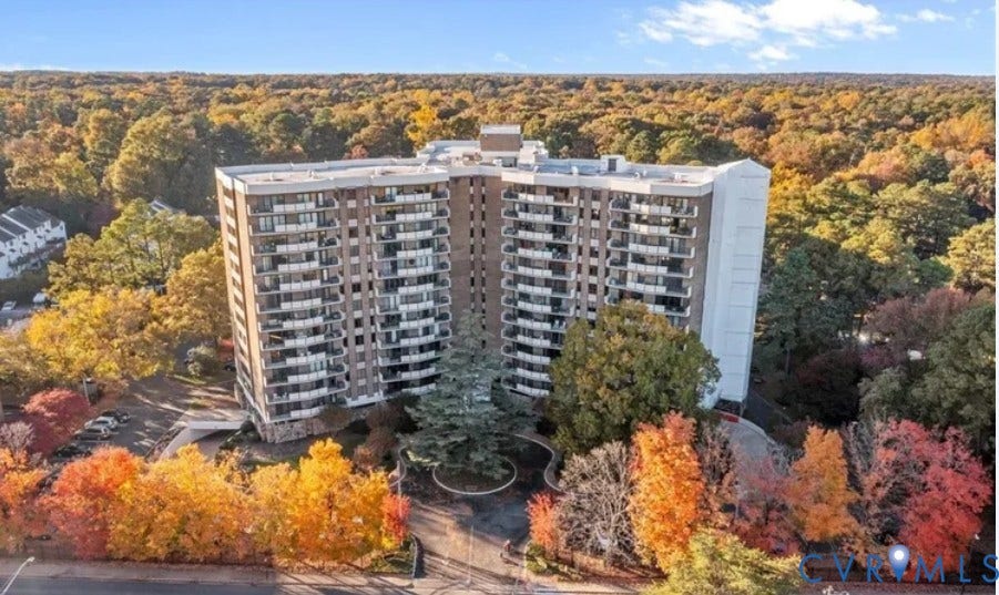 2956 Hathaway Road, #U407, Richmond, VA 23225 Modern mid-rise residential building surrounded by mature landscaping featuring vibrant autumn foliage in shades of gold, orange, and red