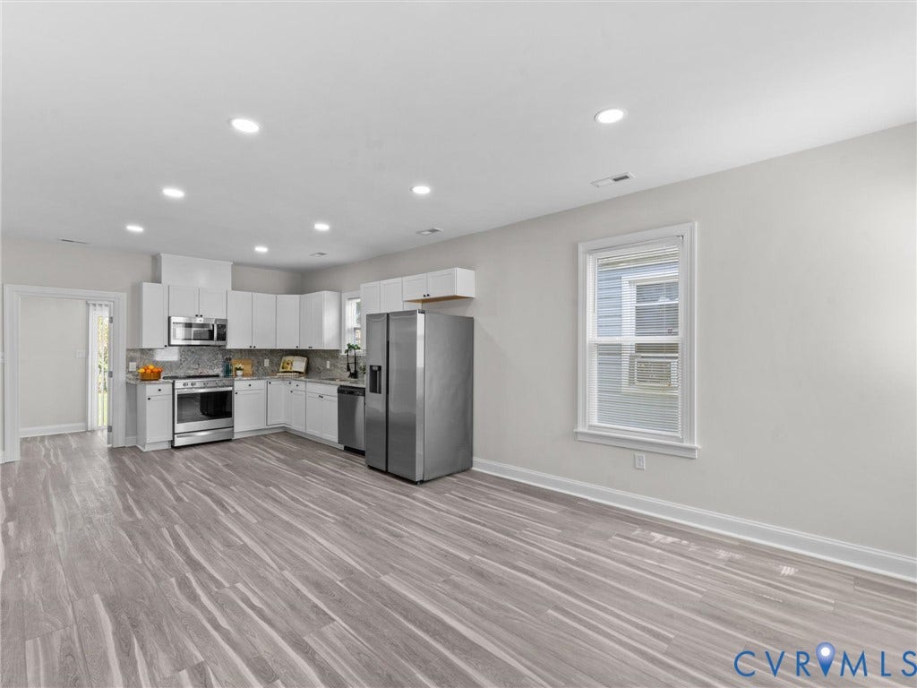 3059 Decatur Street, Richmond, VA 23224 Open-concept Living room, eating area and kitchen featuring white cabinetry, stainless steel appliances, and wood-finish flooring