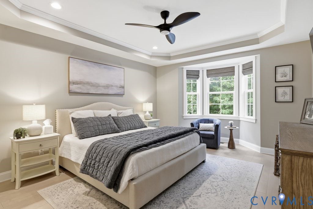 First floor primary with bay window, tray ceiling, wood flooring