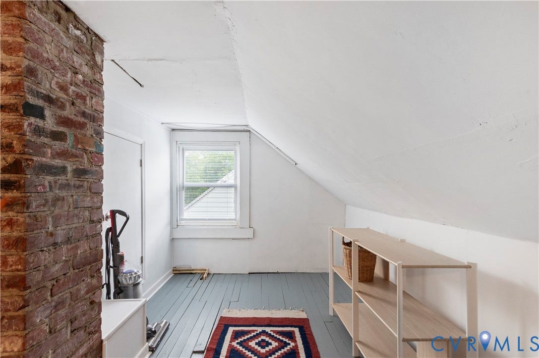 613 Rothesay Road, City Stadium, Richmond, VA 23221 Exposed brick column, painted wood-finish flooring, white sash window, white sloped ceilings, and built-in shelving