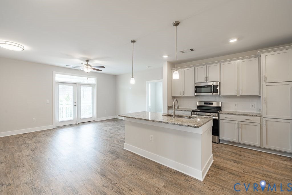 10530 Stony Bluff Drive, #102, Stony Run Condos, Ashland, VA 23005 Open-concept living area featuring wood-finish flooring, a contemporary ceiling fan, and double French doors