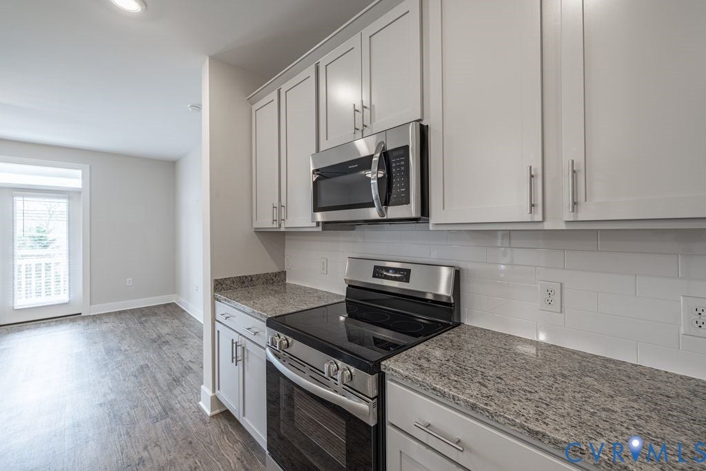 10530 Stony Bluff Drive, #102, Stony Run Condos, Ashland, VA 23005 Kitchen featuring light gray cabinetry, stainless steel appliances, speckled countertops, and a white subway tile backsplash