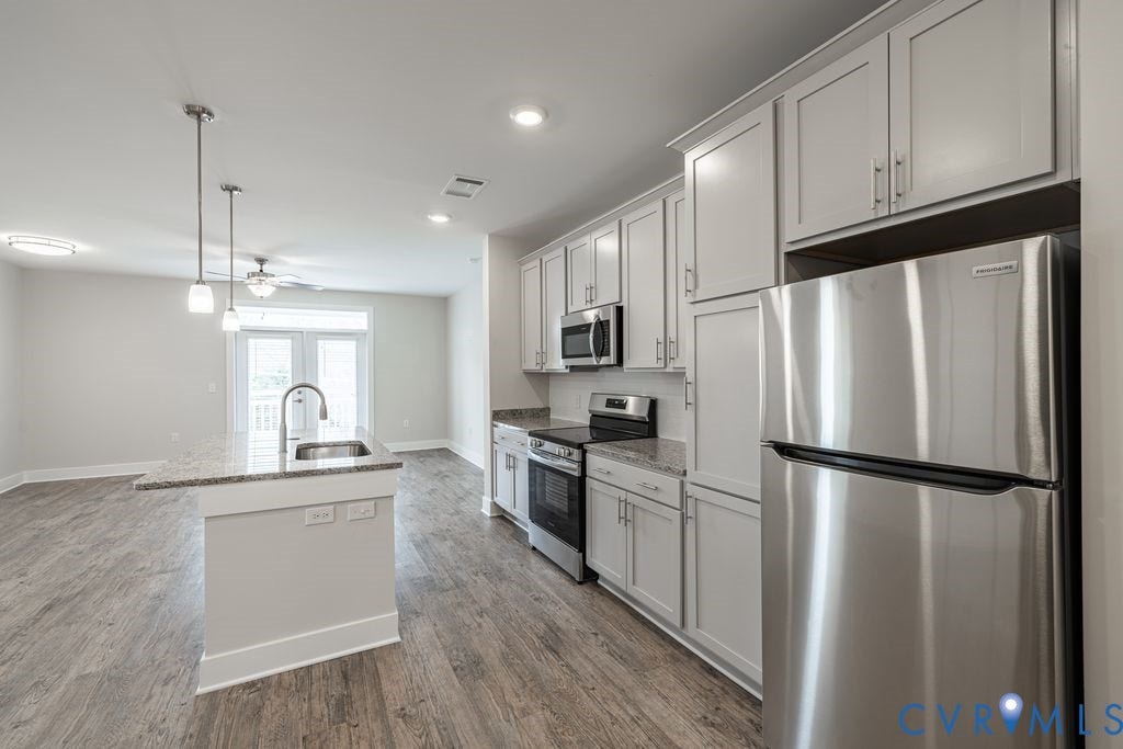 10530 Stony Bluff Drive, #102, Stony Run Condos, Ashland, VA 23005 Kitchen featuring stainless steel appliances, light-toned cabinetry, and wood-finish flooring