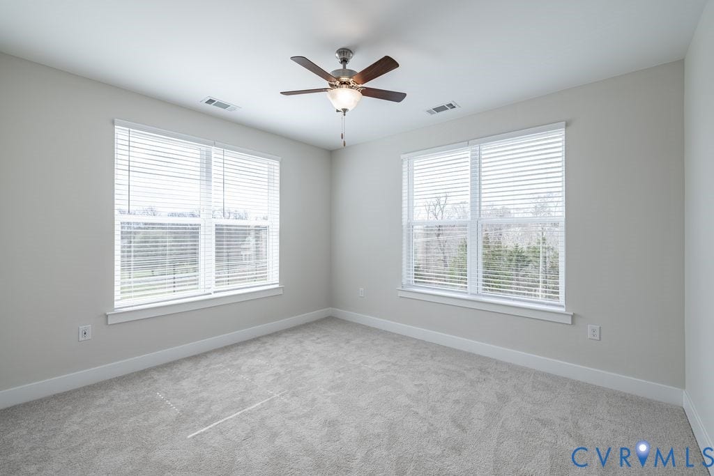 10530 Stony Bluff Drive, #102, Stony Run Condos, Ashland, VA 23005 Light gray wall paint, two large windows with blinds, ceiling fan, and gray carpeting