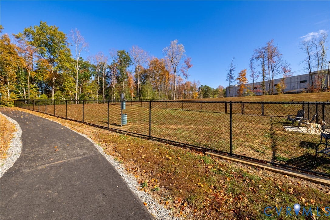 10530 Stony Bluff Drive, #102, Stony Run Condos, Ashland, VA 23005 Fenced Dog Park featuring a paved path, natural landscaping, and a chain-link enclosure