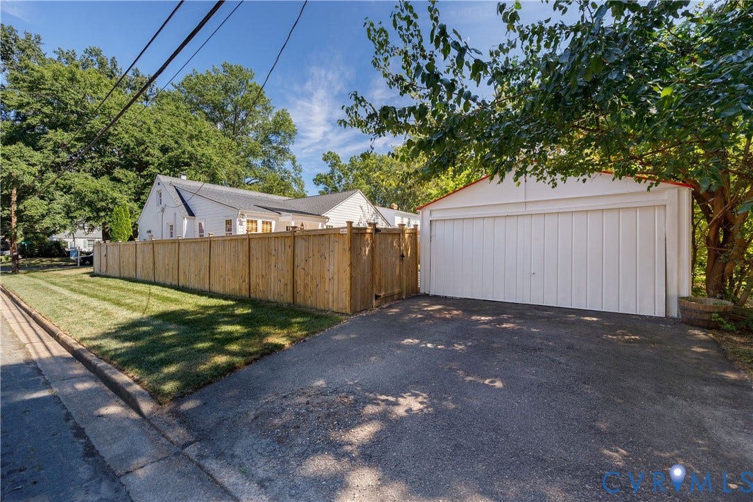 4919 Park Avenue, Near West End, Richmond, VA 23226 Detached two-car garage with white paneled door, asphalt driveway, and wood privacy fence