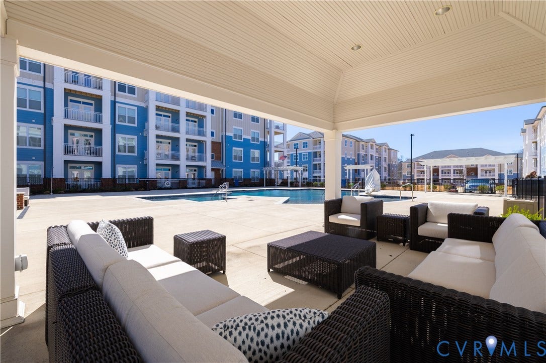 10526 Stony Bluff Drive, #302, Stony Run Condos, Ashland, VA 23005 Covered outdoor patio with recessed lighting, an integrated swimming pool, and surrounding multi-story buildings