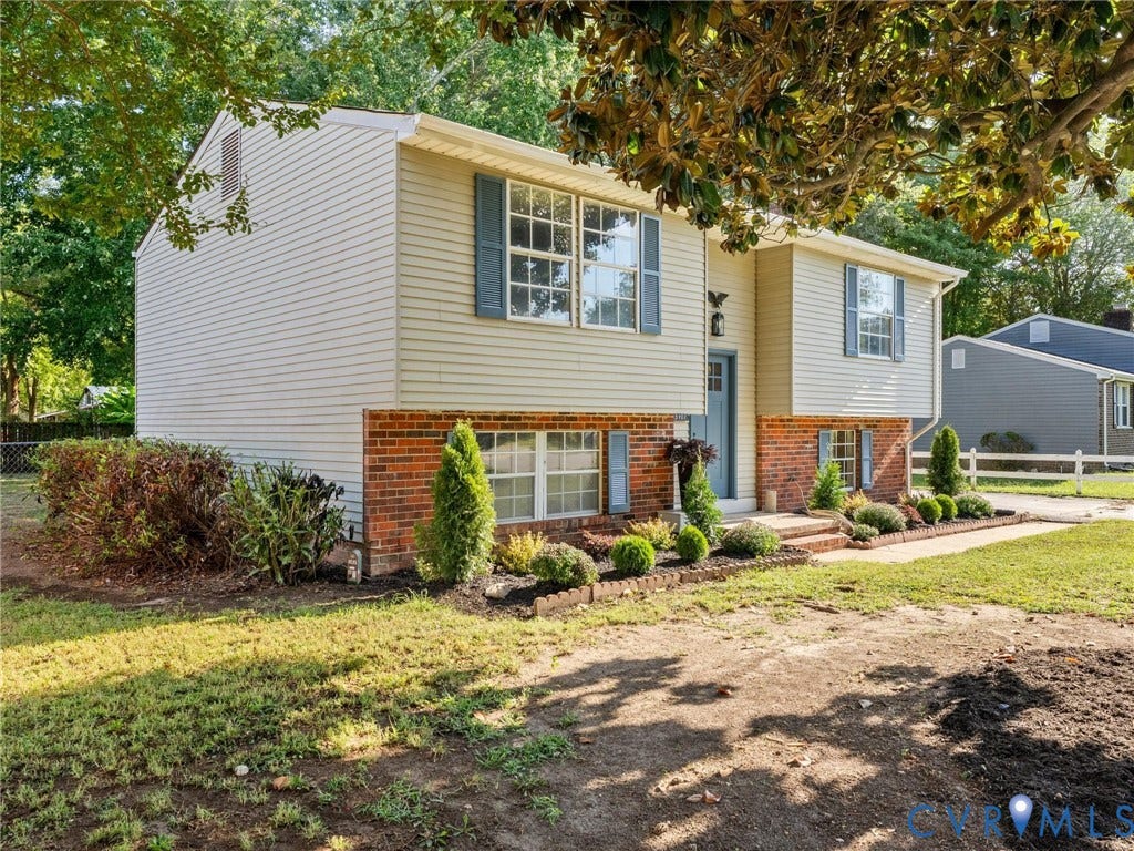 5907 Stella Road, Richmond, VA 23234 Split-level residence featuring brick and siding exterior, front door, multiple windows with shutters, and established landscaping