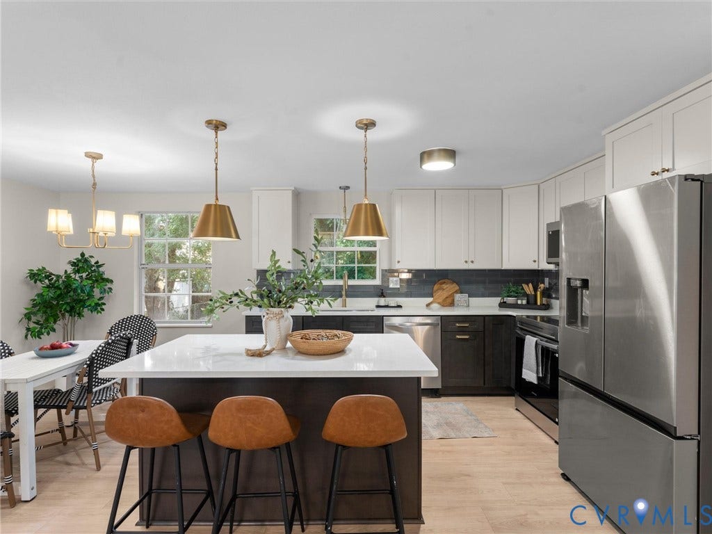 5907 Stella Road, Richmond, VA 23234 Kitchen featuring a center island with solid surface countertop, two-tone cabinetry, stainless steel appliances, and wood-finish flooring