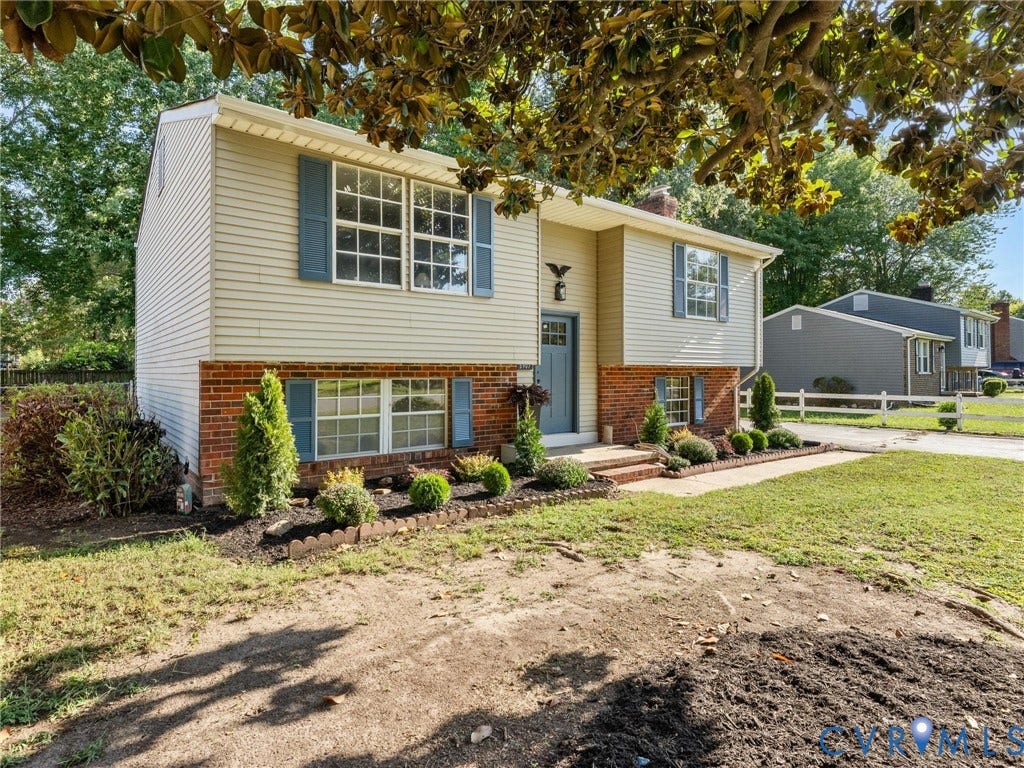 5907 Stella Road, Richmond, VA 23234 Two-story exterior with siding and brick accents, blue shutters, a blue front door, and a landscaped garden bed