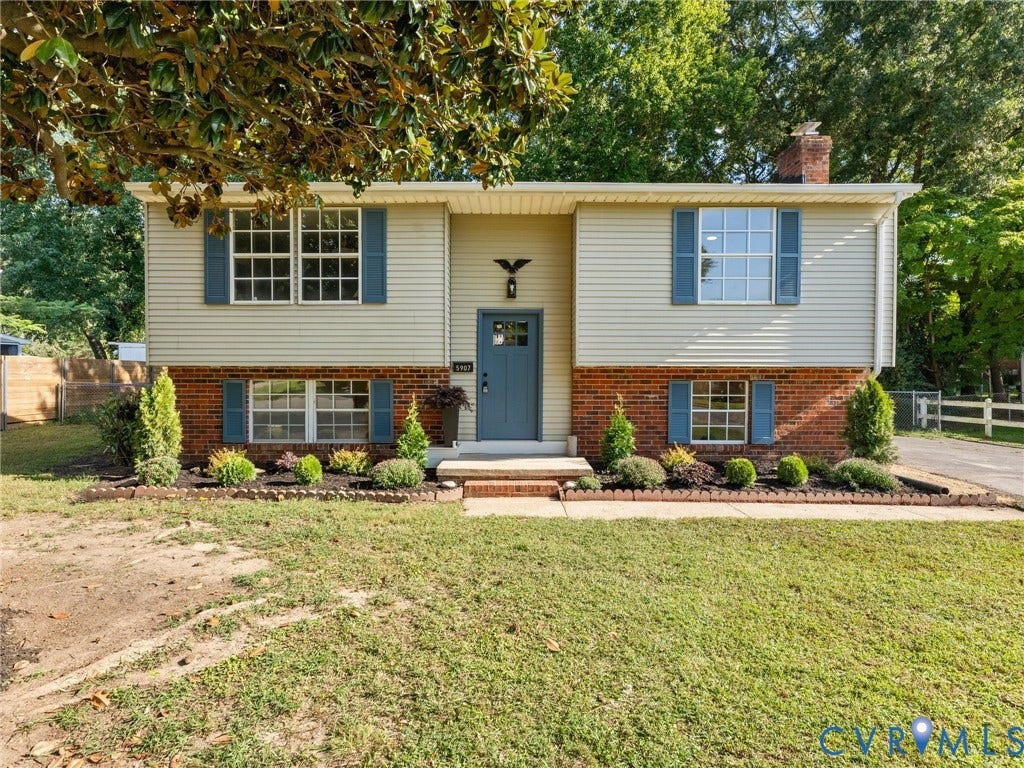 5907 Stella Road, Richmond, VA 23234 Two-story exterior featuring brick and siding finishes, a prominent front door with a transom window, and multiple paneled windows with decorative shutters