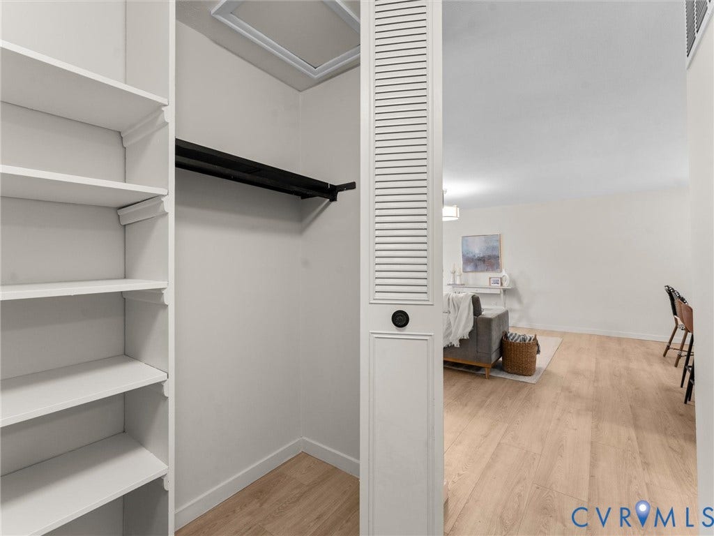5907 Stella Road, Richmond, VA 23234 White shelving system, black closet rod, wood-finish flooring, white walls, louvered partition