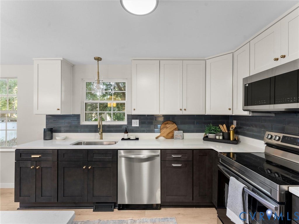5907 Stella Road, Richmond, VA 23234 Two-tone cabinetry with white upper and dark wood-finish lower cabinets, stainless steel appliances, white countertops, and a dark tile backsplash