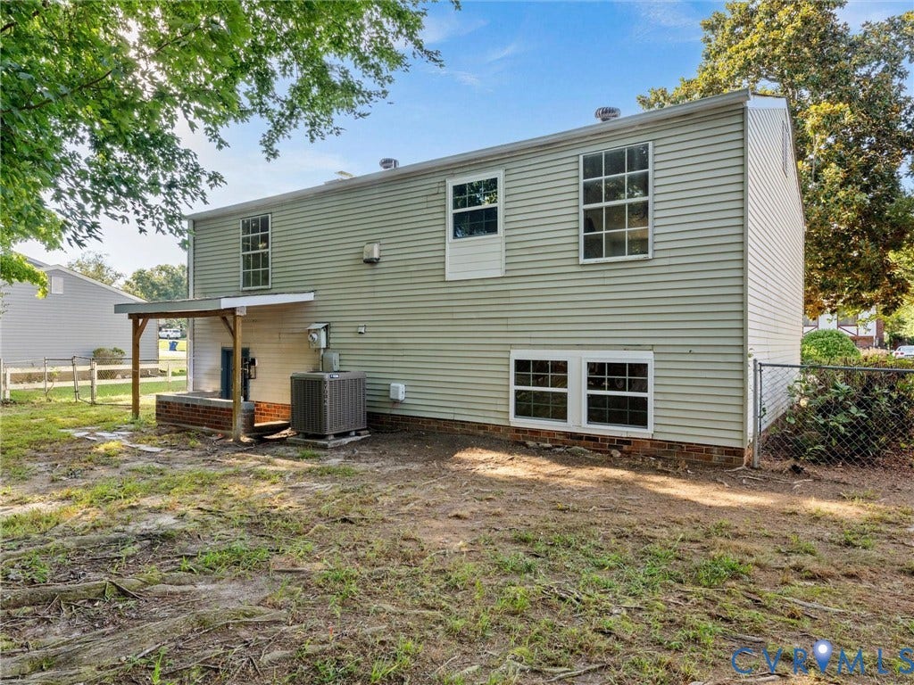 5907 Stella Road, Richmond, VA 23234 Rear exterior with horizontal siding, covered porch with wood supports, and chain-link fencing