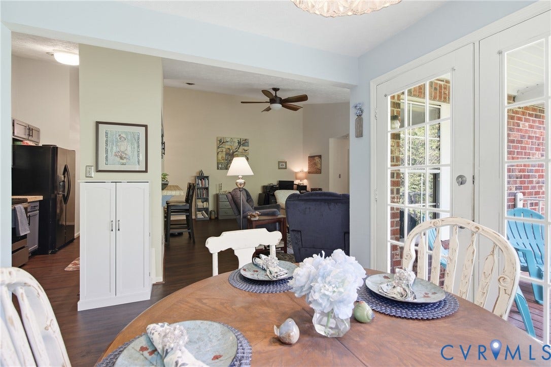 Dining area featuring French doors opening to an exterior patio, with LVP flooring extending into the adjoining living space