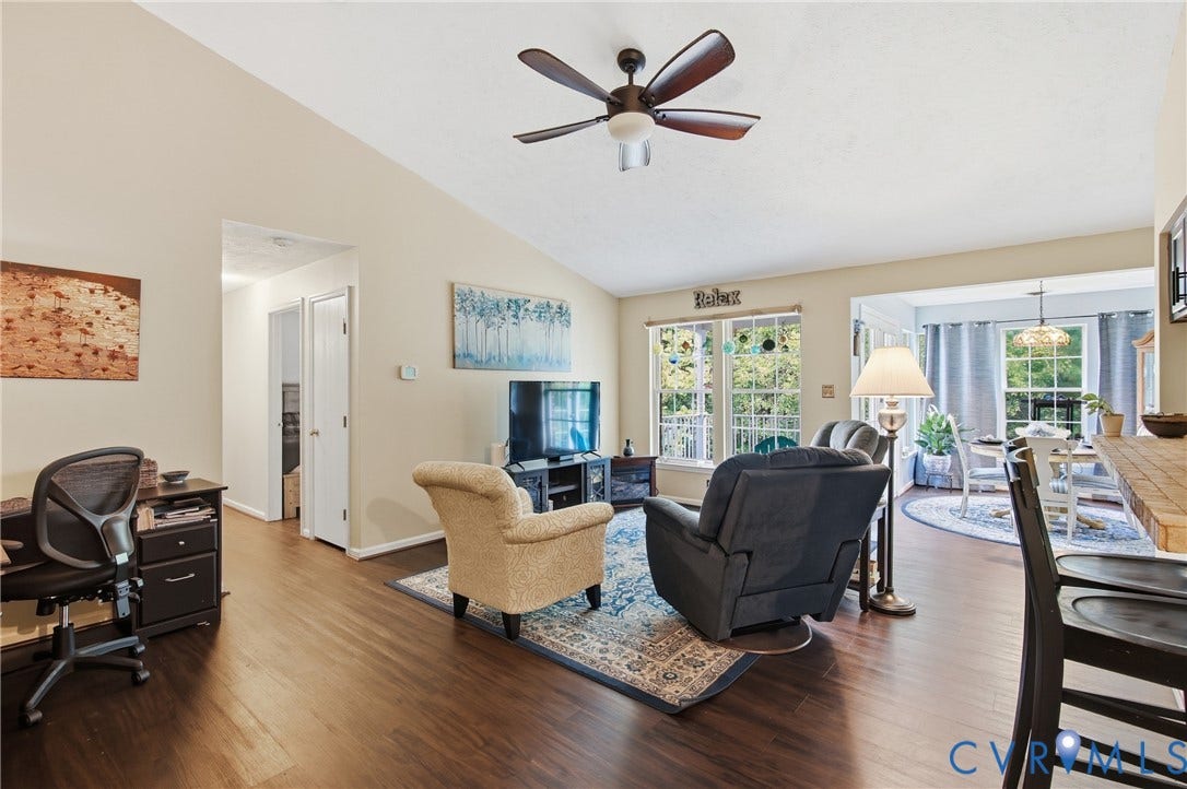 Vaulted ceiling with ceiling fan, LVP flooring, and a breakfast bar