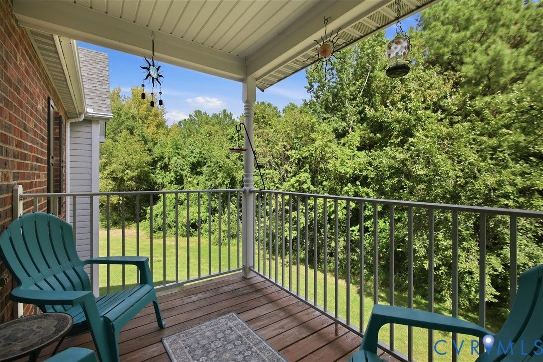 Covered balcony overlooking the peaceful wooded green space.