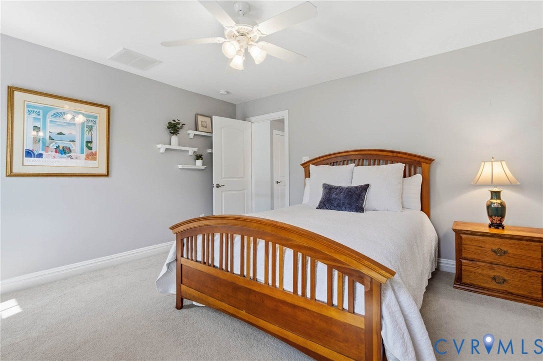 Neutral-toned carpeting, light gray wall paint, white trim, and a ceiling fan with integrated lighting