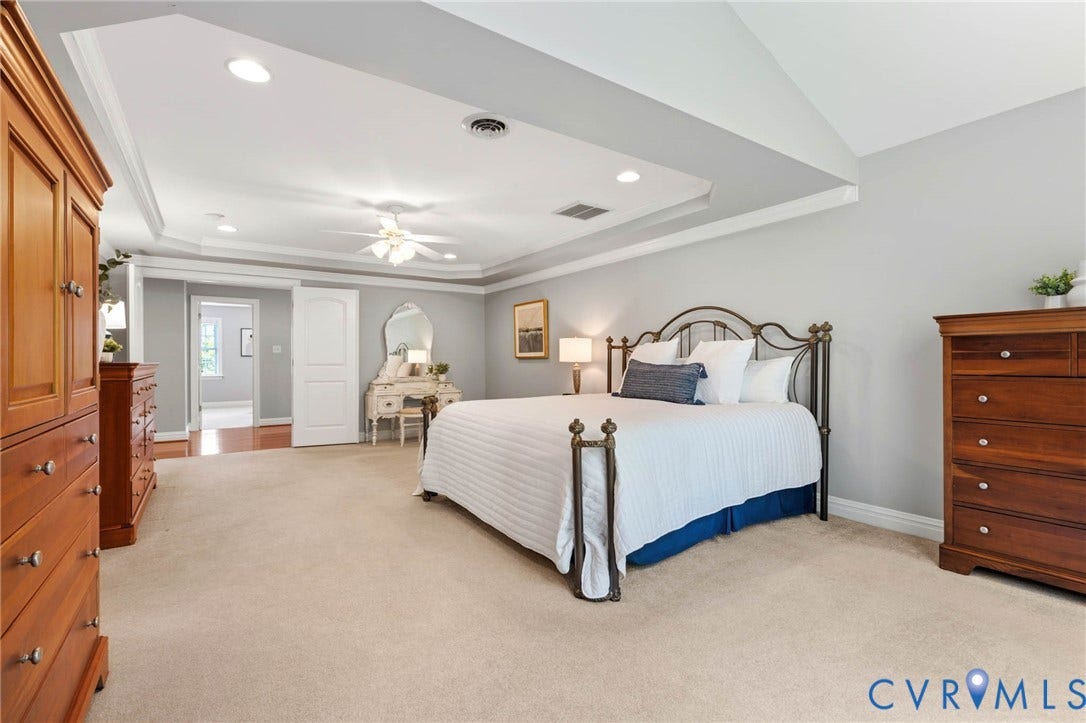 Tray ceiling with recessed lighting, ceiling fan, neutral carpet flooring, light gray wall paint, and white trim