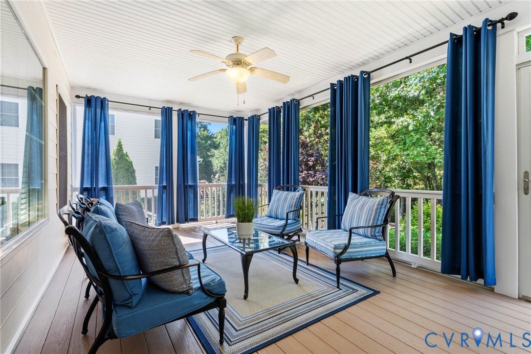 Screened porch featuring a ceiling fan with integrated lighting, wood-finish flooring, and white railings