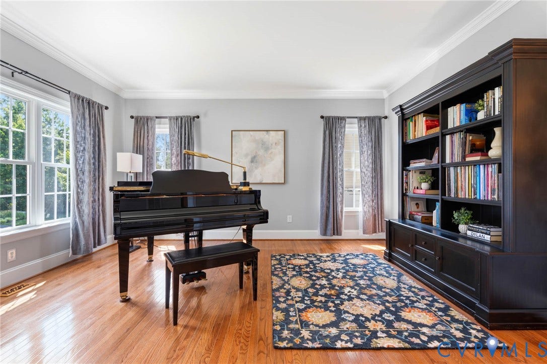Hardwood flooring, crown molding, and large multi-pane windows