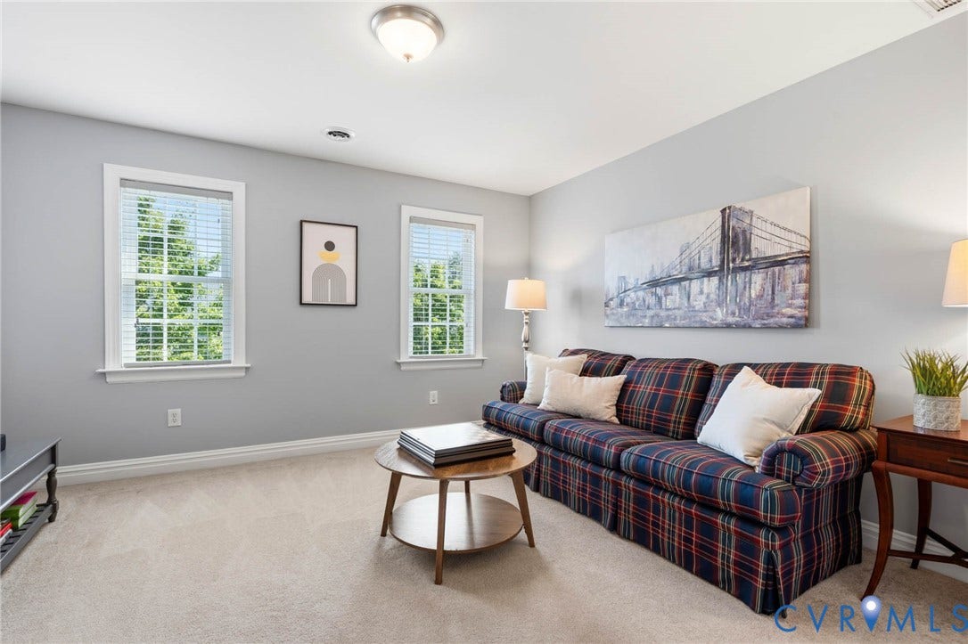 Light gray painted walls, two windows with white trim, wall-to-wall carpeting, and a flush mount ceiling light