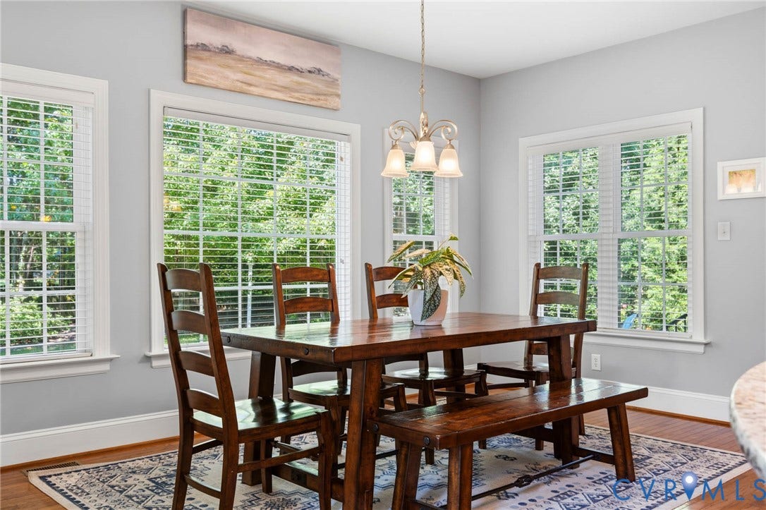 Hardwood flooring, light gray wall color, multiple large windows, white window trim, and a built-in light fixture