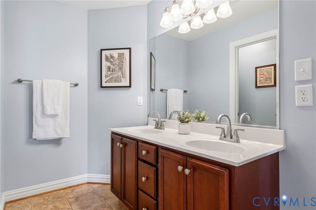 Dual vanity with white undermount sinks, chrome fixtures, and a white countertop
