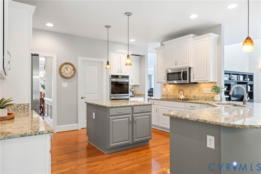 Kitchen featuring wood-finish flooring, recessed lighting, white cabinetry, and light-toned countertops