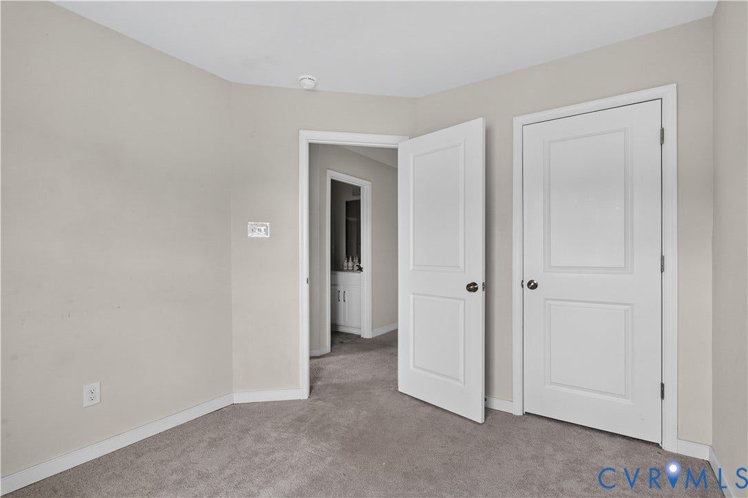 Neutral tone wall paint, light gray carpeting, white panel doors, and white trim