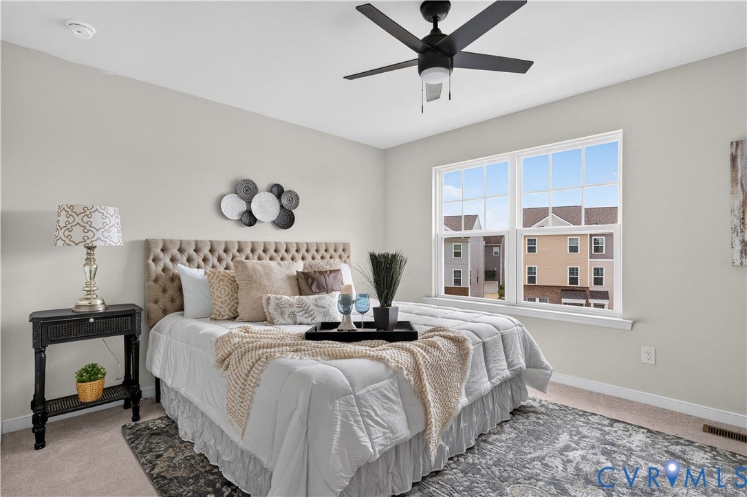 Window with grid pattern, neutral wall paint, ceiling fan with integrated lighting, and carpeted flooring