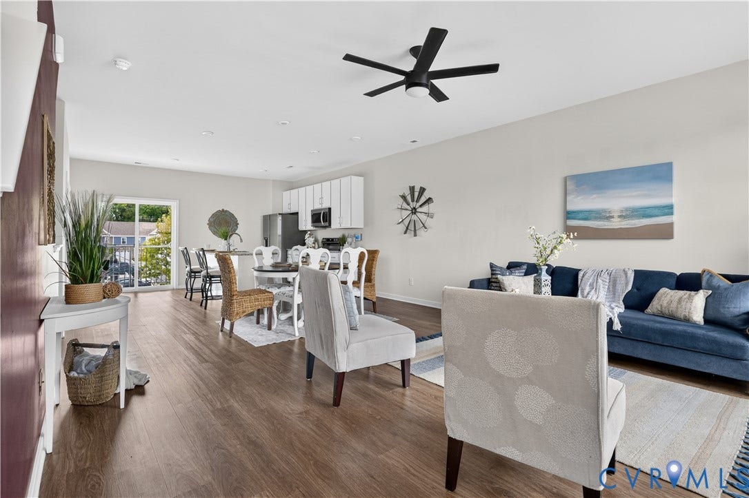 Open-concept living space with wood-finish flooring, a contemporary ceiling fan, recessed lighting, and a sliding glass door