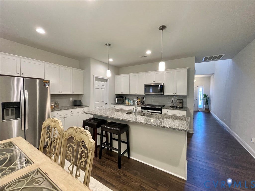 6905 Leire Lane, Chesterfield, VA 23832 Kitchen featuring white cabinetry, stainless steel appliances, a center island with bar seating, and wood-finish flooring