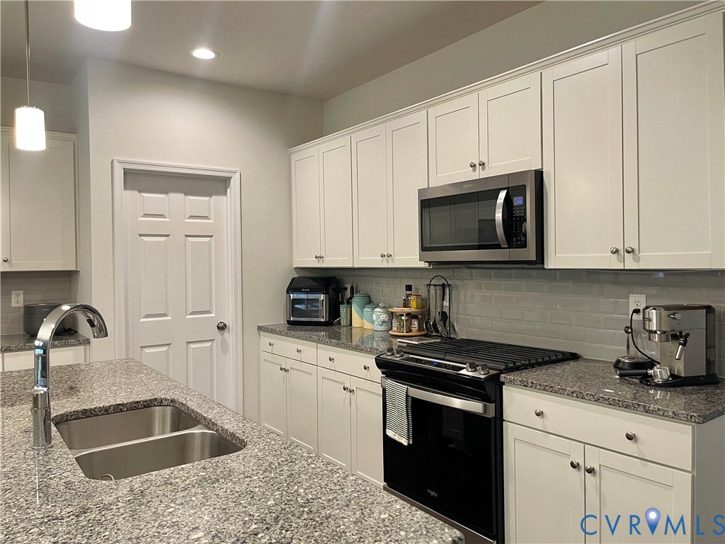 6905 Leire Lane, Chesterfield, VA 23832 Light-toned cabinetry, granite countertops, stainless steel appliances, a subway tile backsplash, and a double basin sink