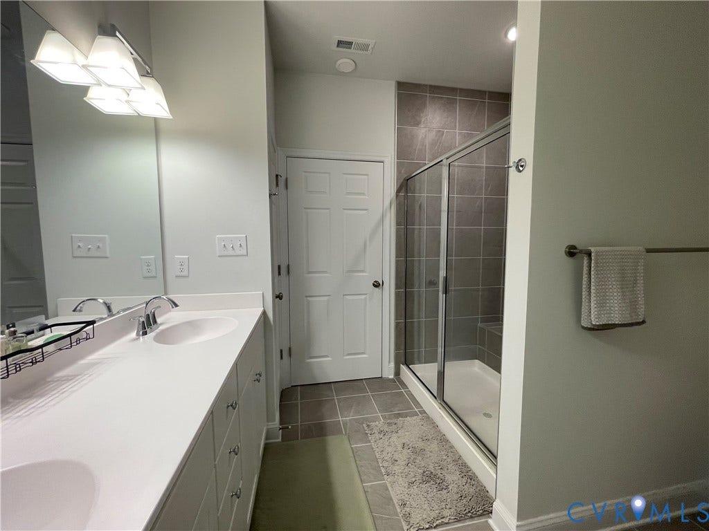 6905 Leire Lane, Chesterfield, VA 23832 Dual sink vanity with white countertop, chrome fixtures, and mounted mirror