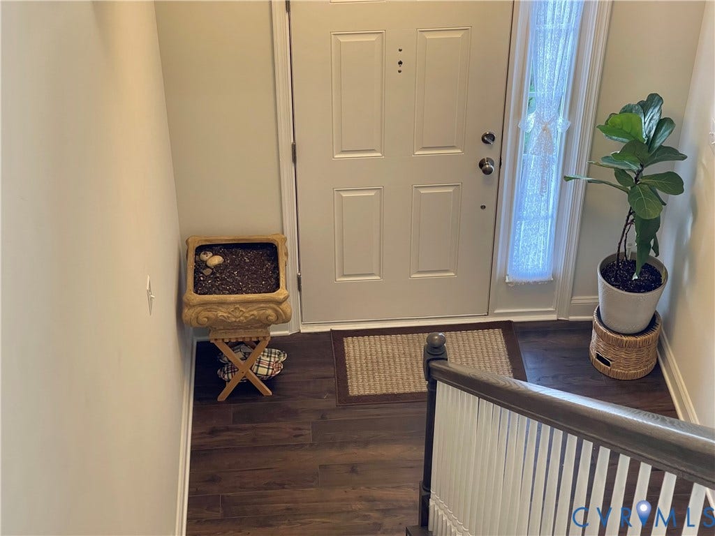 6905 Leire Lane, Chesterfield, VA 23832 Entryway featuring a paneled door with sidelight, dark wood-finish flooring, and a staircase with white spindles and a wood handrail