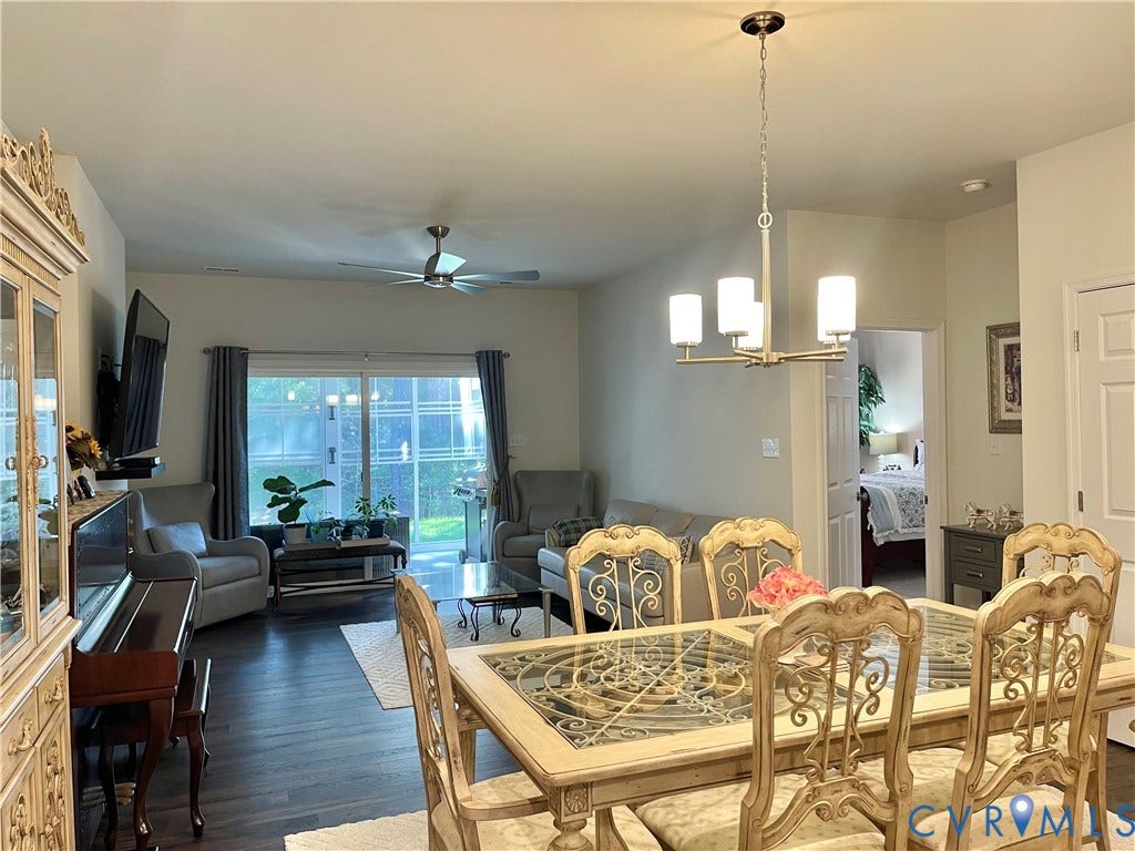 6905 Leire Lane, Chesterfield, VA 23832 Open-concept living and dining areas featuring dark wood-finish flooring, a contemporary chandelier, and a ceiling fan