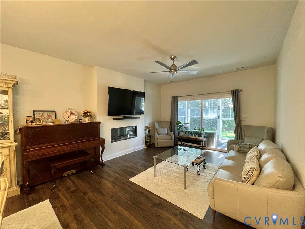 6905 Leire Lane, Chesterfield, VA 23832 Wood-finish flooring throughout, featuring a linear fireplace, wall-mounted television, and a ceiling fan
